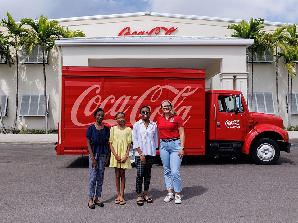 Caribbean Bottling Company staff beside a Coca-Cola delivery truck at the Nassau plant