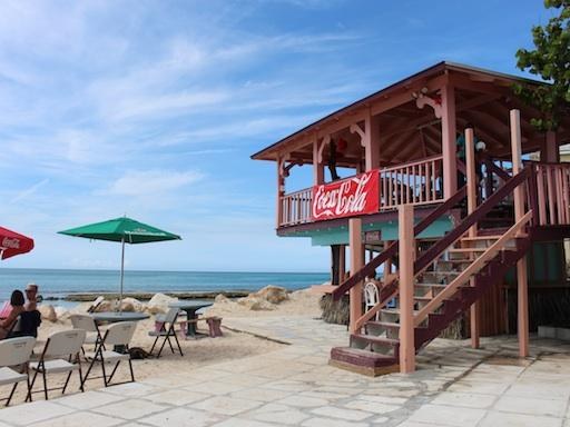 Two Bahamas Coca-Cola glasses raised over the water